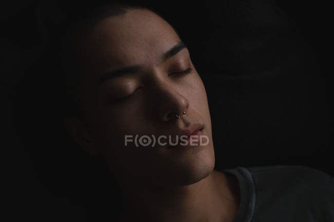 Close up of young man lying on sofa in living room — Stock Photo
