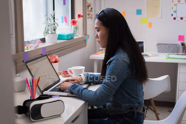 Female designer using laptop in design studio office. — Stock Photo