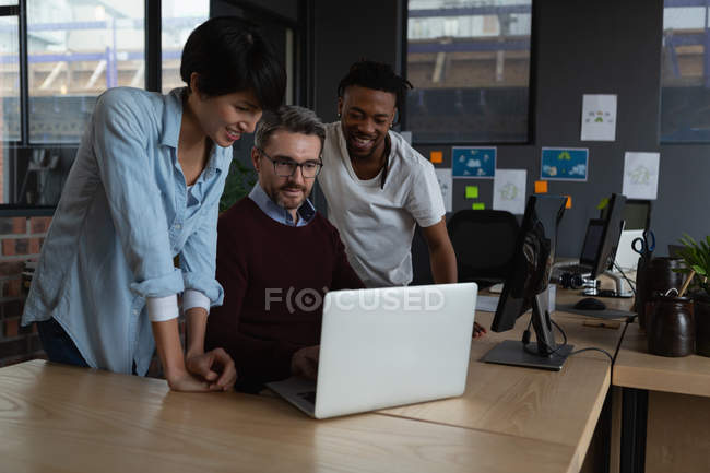Führungskräfte diskutieren über Laptop am Schreibtisch im Büro. — Stockfoto