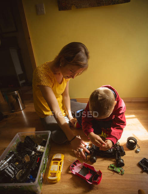 Mutter und Sohn reparieren Spielzeugauto im Schlafzimmer zu Hause — Stockfoto