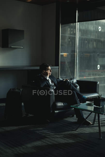 Empresário falando ao telefone enquanto toma café no hotel — Fotografia de Stock