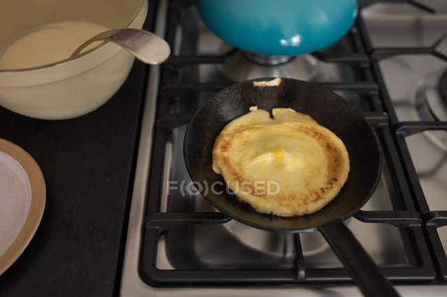 Крупним планом приготування млинців на сковороді на плиті в домашніх умовах . — стокове фото