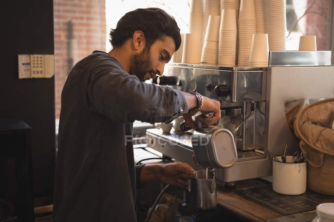 Barista gießt Milch in Krug am Tresen im Coffeeshop — Stockfoto