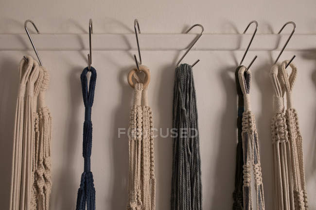 Various dyed thread on hook against wall — Stock Photo