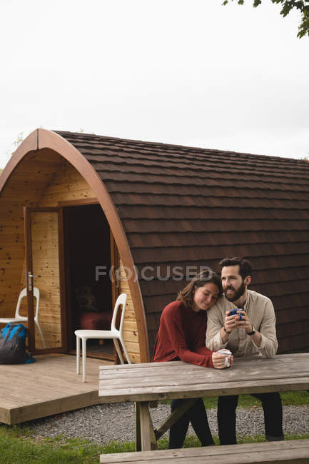 Счастливая пара пьет кофе за дверью хижины — стоковое фото