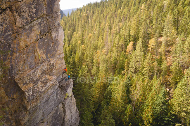 Entschlossener Bergsteiger erklimmt die felsige Klippe — Stockfoto