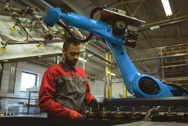 Рабочий мужчина проверяет детали машины на заводе — стоковое фото
