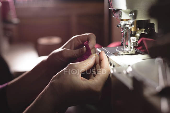 Mid section tailor sewing cloth with sewing machine at tailor shop — Stock Photo