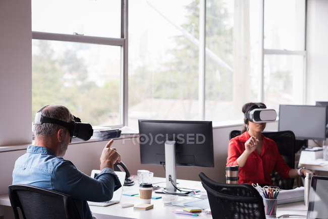 Офісних колег відчувають віртуальної реальності гарнітуру на реєстрації в творчих office — стокове фото