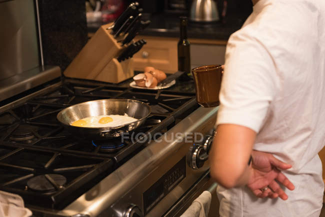 Uomo che prepara il cibo in cucina a casa — Foto stock