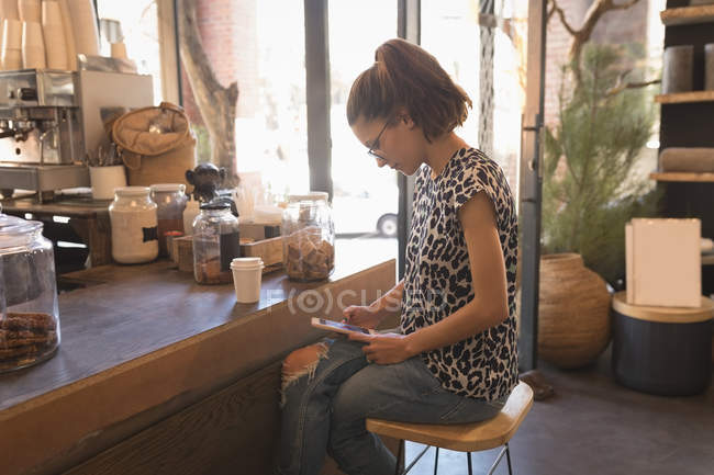 Frau nutzt digitales Tablet am Tresen im Café — Stockfoto