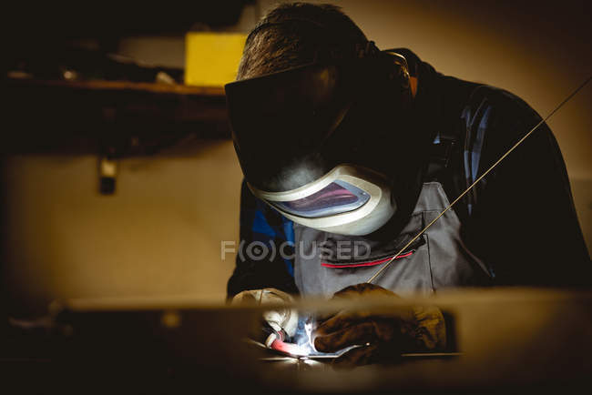 Arbeiter, der in der Fabrik an gefertigten Metallteilen arbeitet — Stockfoto