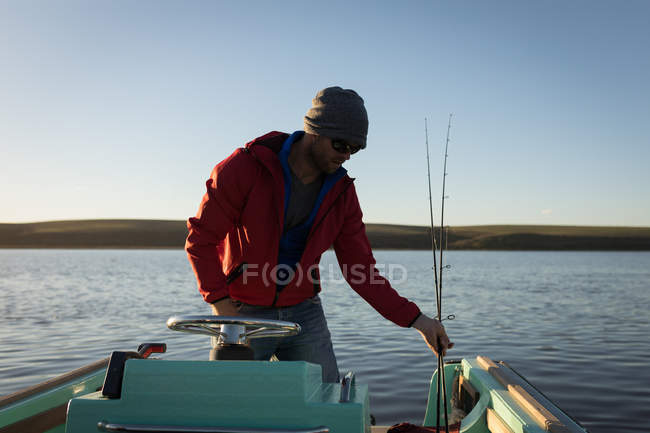 Homem montando barco a motor no rio à luz do sol . — Fotografia de Stock
