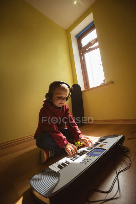 Kleiner Junge spielt zu Hause im Schlafzimmer Klavier — Stockfoto