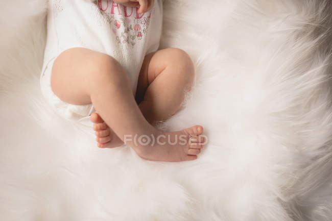 Обрезанный вид новорожденного ребенка, лежащего на пушистом одеяле . — стоковое фото