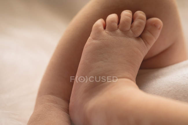 Close-up of foot of newborn baby on baby bed. — Stock Photo
