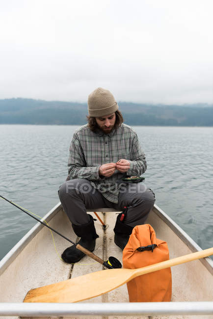 Mann im Boot fixiert Köder an der Angelschnur — Stockfoto