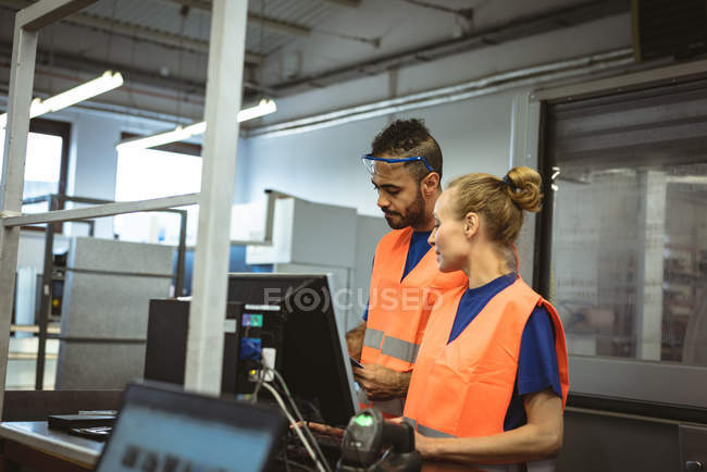Two workers discussing with each other in factory — Stock Photo