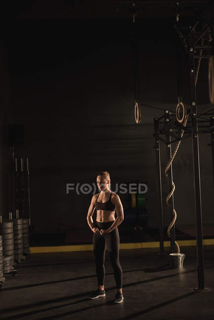 М'язова жінка показує її м'язи в тренажерному залі — стокове фото