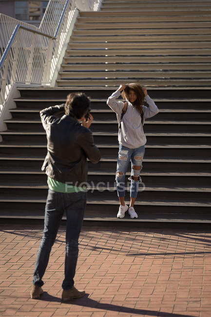 Fotógrafo tirar fotos de um modelo na rua em um dia ensolarado — Fotografia de Stock