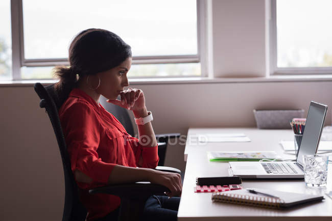 Donna d'affari concentrata che lavora su computer portatile in ufficio — Foto stock