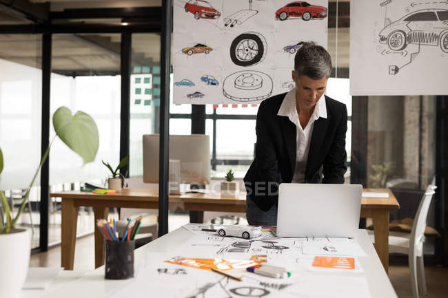 Femme d'affaires attentive en utilisant un ordinateur portable dans le bureau . — Photo de stock
