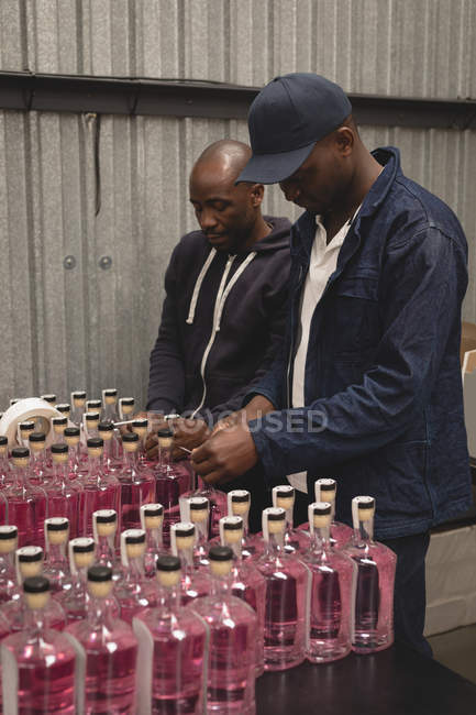 Workers packing gin bottles in the factory — Stock Photo