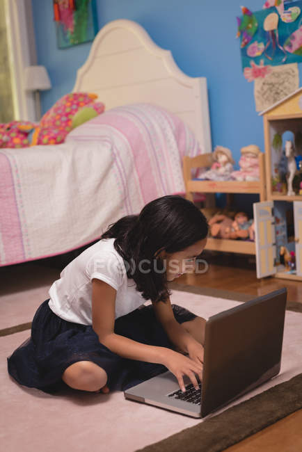 Ragazza utilizzando il computer portatile in camera da letto a casa — Foto stock