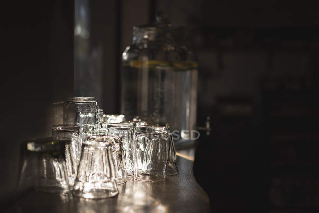 Glasses arranged on table in cafe at dark — Stock Photo