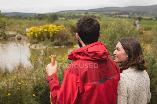 Couple interacting with each other near pond — Stock Photo