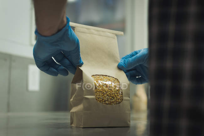 Mid section of man packing grains in factory — Stock Photo