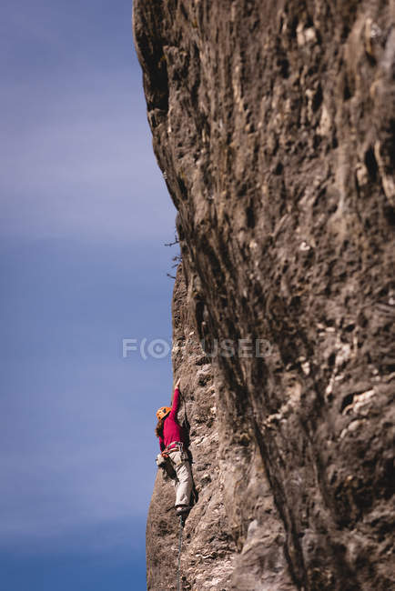 Скеля climber досягнення на вершині скелі на сонячний день — стокове фото