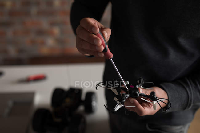 Mid section of male electrical engineer repairing drone. — Stock Photo
