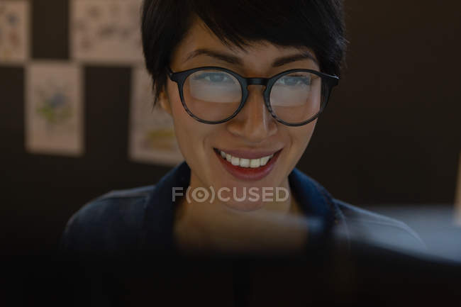 Close-up of female executive in glasses working by computer in office. — Stock Photo