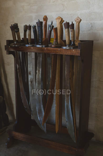 Swords arranged on wooden rack in fitness studio. — Stock Photo