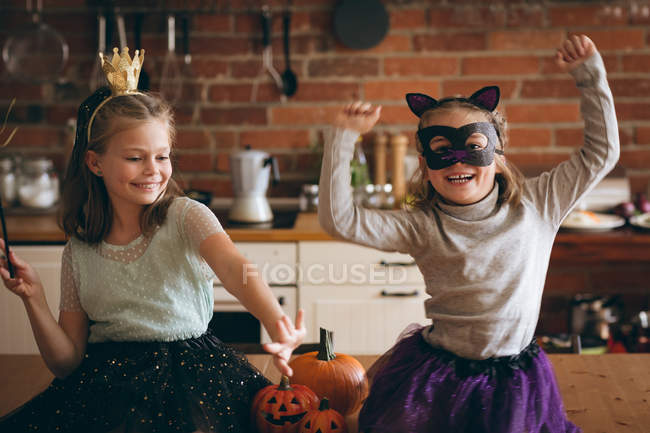 Meninas em traje dançando na cozinha em casa — Fotografia de Stock