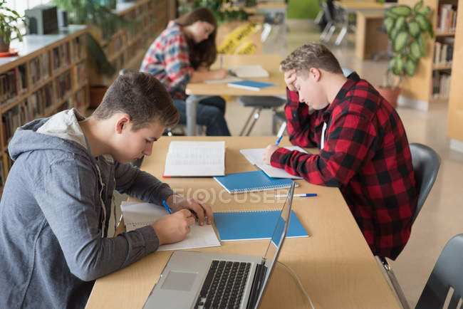 College students studying in library at university — Stock Photo