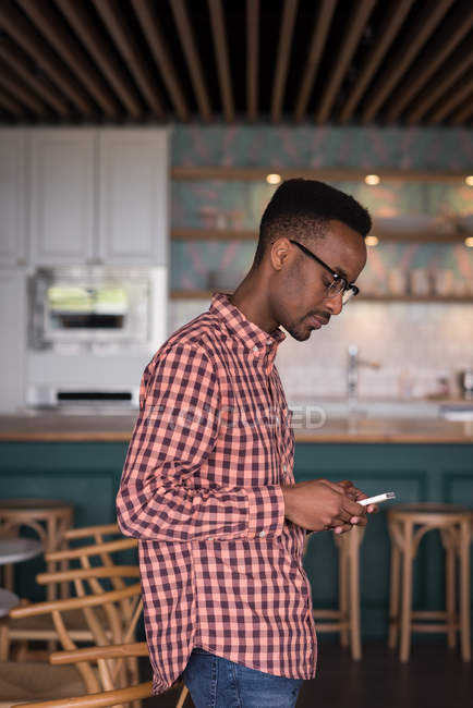 Executivo de escritório masculino usando telefone celular na cafetaria no escritório criativo — Fotografia de Stock