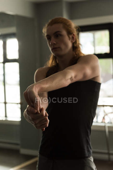 Man practicing stretching exercise in fitness studio. — Stock Photo
