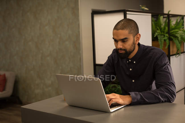 Мужчина-руководитель работает на ноутбуке в кафетерии в офисе — стоковое фото