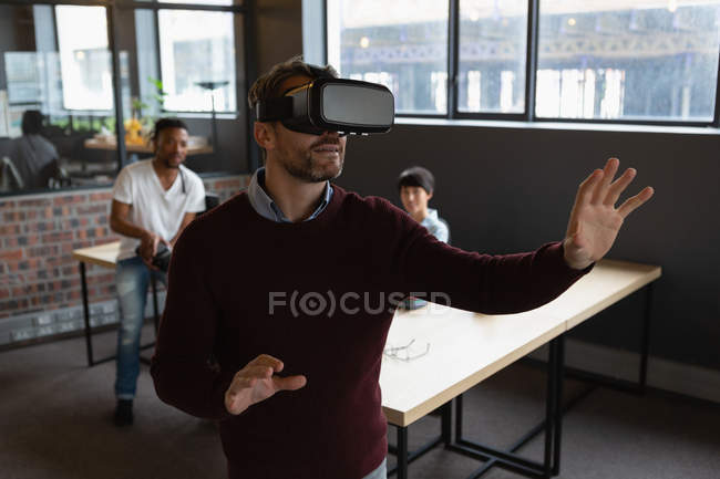 Возбужденный человек, испытывающий в офисе гарнитуру виртуальной реальности . — стоковое фото