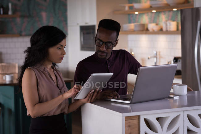 Office colleagues discussing over laptop and digital tablet in the office — Stock Photo