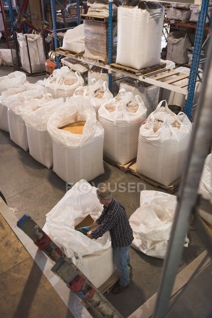 Vista ad alto angolo di uomo uomo che imballa cereali a sacco — Foto stock