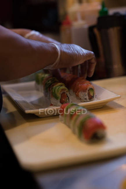 Chef préparant des sushis sur un plateau dans la cuisine — Photo de stock