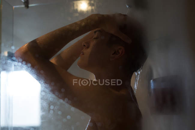 Молодий чоловік приймає душ у ванній вдома — стокове фото