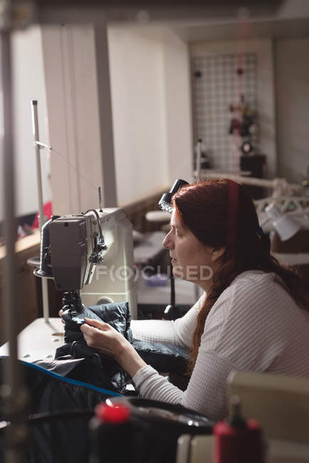 Sastre de tela de coser con máquina de coser en sastrería - foto de stock