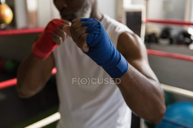 Mid section of senior man boxing in fitness studio. — Stock Photo