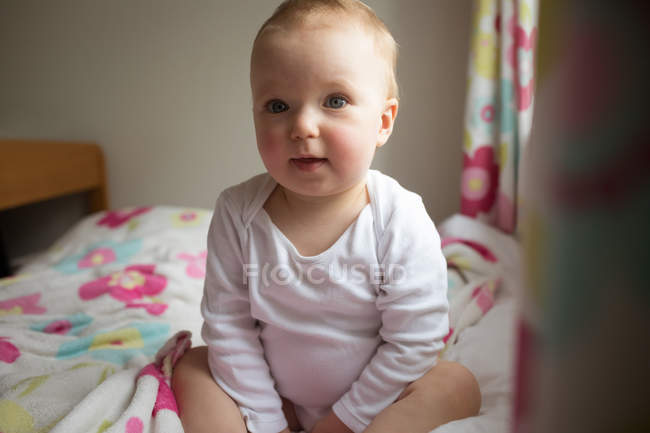 Bambina seduta in camera da letto a casa — Foto stock