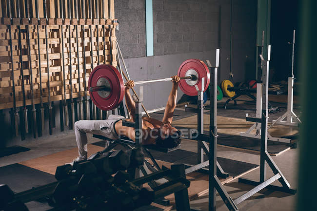 Muskelprotz trainiert mit Langhantel im Fitnessstudio — Stockfoto