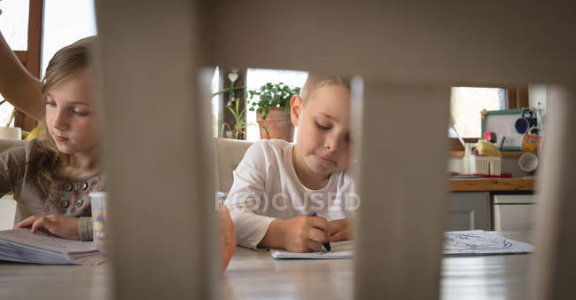 Niños estudiando en la mesa en casa - foto de stock